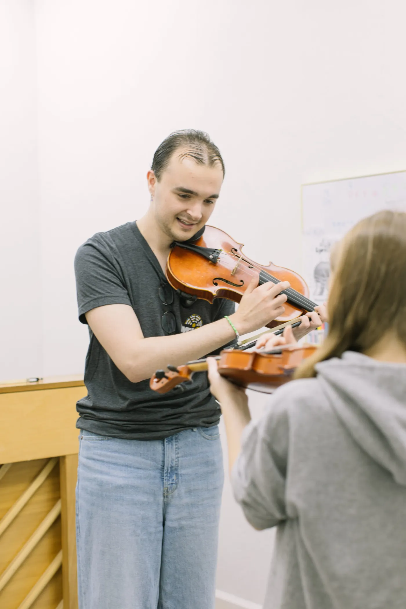 Violin teacher guiding a student during a string lesson at LyriCo Conservatory